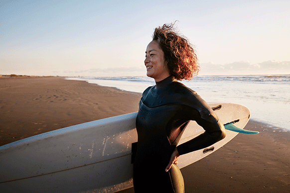 woman carrying surfboard at the beach